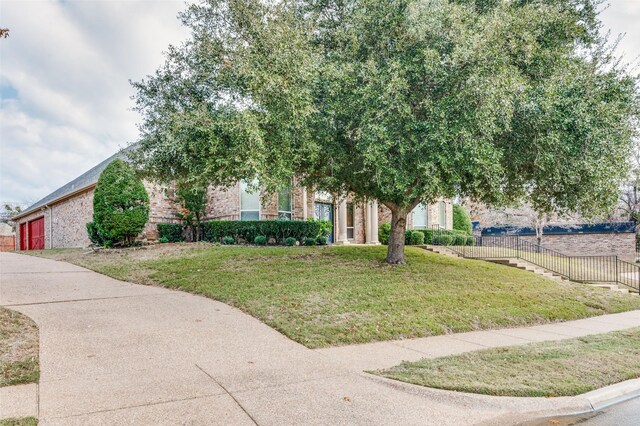 obstructed view of property with a front lawn