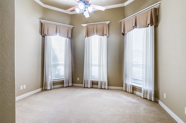 empty room with ceiling fan, light colored carpet, and ornamental molding