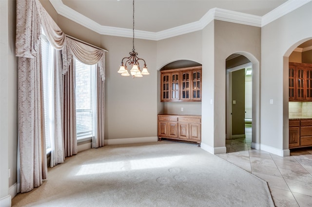 unfurnished dining area featuring light colored carpet, ornamental molding, and a notable chandelier