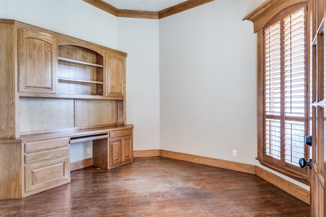 unfurnished office featuring built in desk, ornamental molding, and dark hardwood / wood-style floors