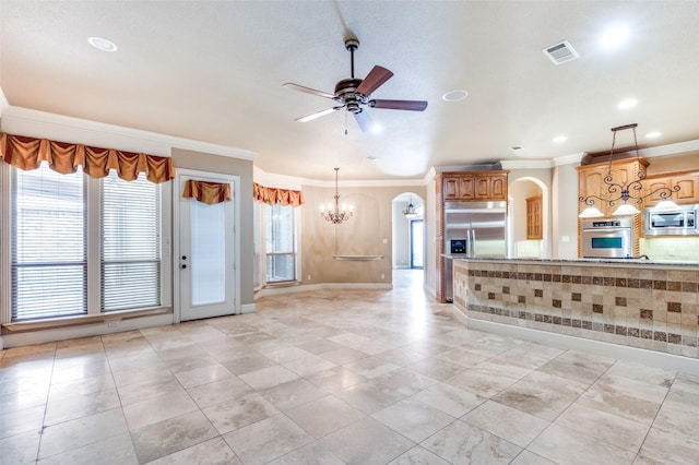 kitchen featuring ceiling fan with notable chandelier, ornamental molding, built in appliances, light tile patterned floors, and light stone countertops