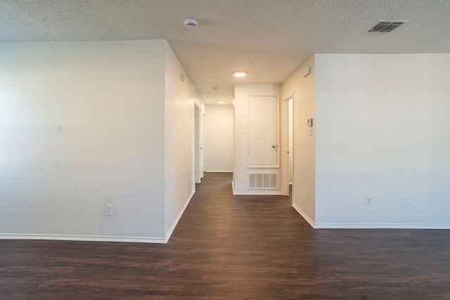 corridor featuring dark hardwood / wood-style flooring and a textured ceiling