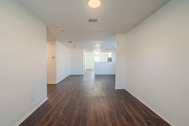 unfurnished room with dark hardwood / wood-style flooring and a textured ceiling