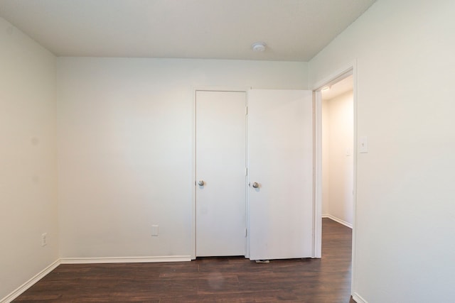 unfurnished bedroom with dark hardwood / wood-style flooring