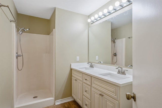 bathroom with hardwood / wood-style flooring, vanity, and walk in shower