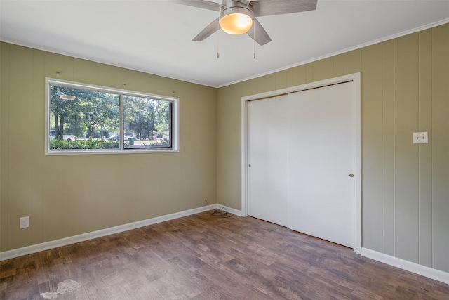 unfurnished bedroom with ceiling fan, wood-type flooring, crown molding, and a closet