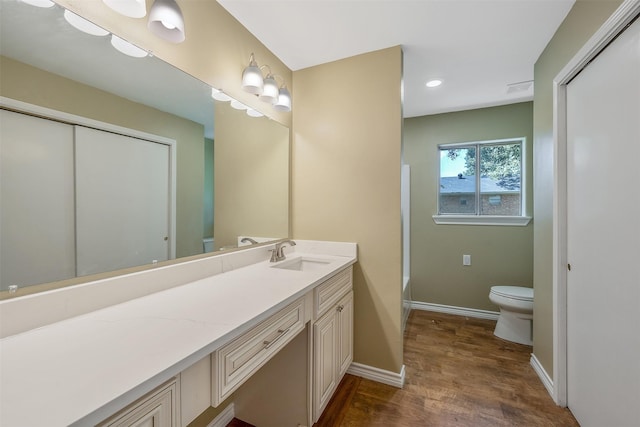 bathroom featuring vanity, wood-type flooring, and toilet