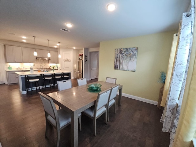 dining area with dark wood-type flooring and sink