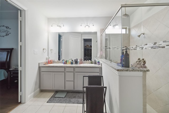 bathroom with tile patterned floors, vanity, and tiled shower