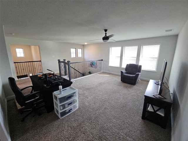 carpeted living room with ceiling fan and a textured ceiling