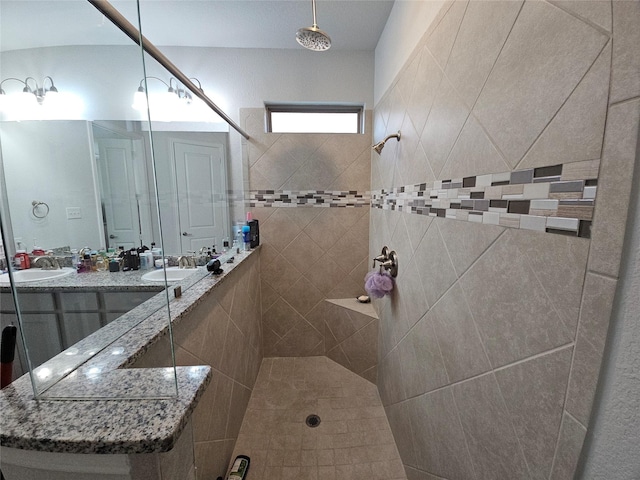 bathroom featuring a tile shower and sink