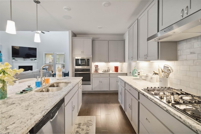 kitchen featuring light stone countertops, stainless steel appliances, tasteful backsplash, and sink