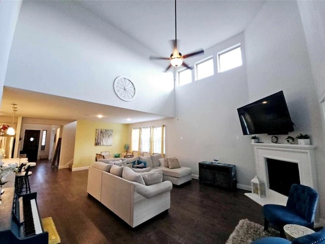 living room with ceiling fan, dark hardwood / wood-style floors, and a high ceiling