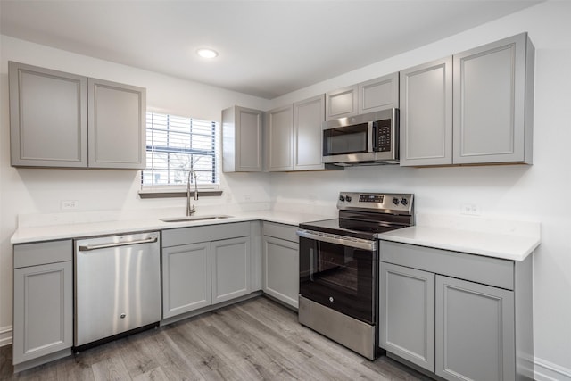 kitchen featuring gray cabinetry, sink, and appliances with stainless steel finishes