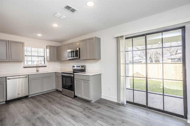 kitchen with gray cabinets, sink, and stainless steel appliances