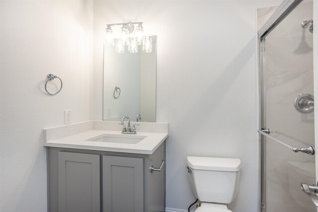 bathroom with vanity, toilet, and a shower with shower door