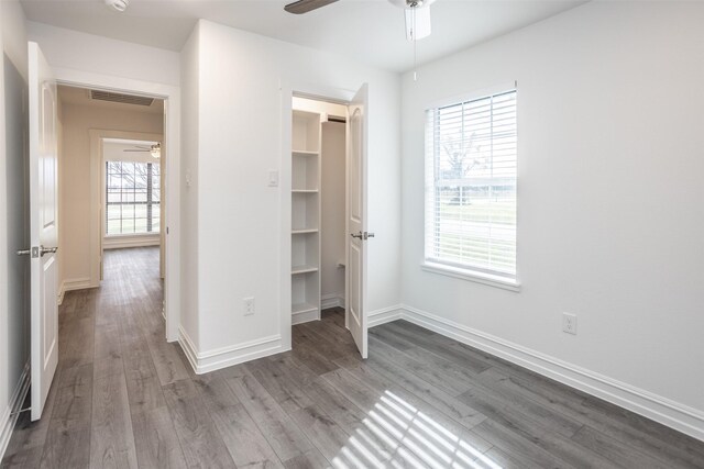 unfurnished bedroom with hardwood / wood-style flooring, ceiling fan, and multiple windows