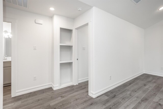 unfurnished bedroom with hardwood / wood-style flooring and sink