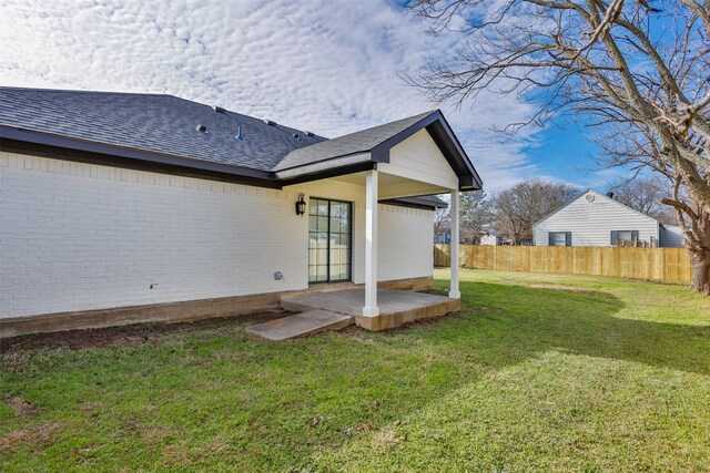 rear view of house with a lawn and a patio area