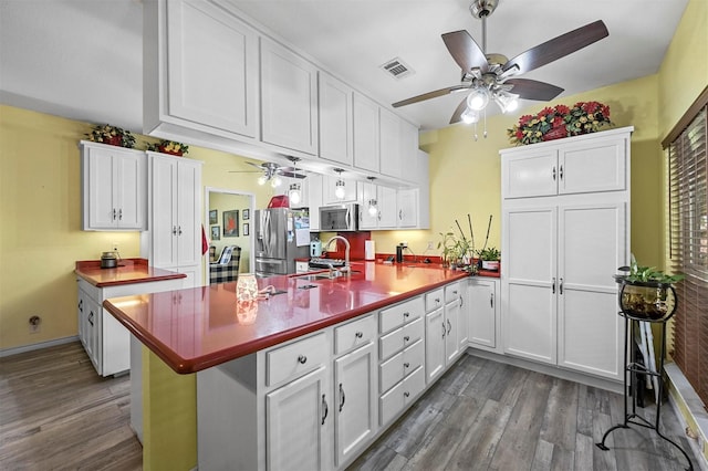 kitchen with white cabinetry, kitchen peninsula, and appliances with stainless steel finishes