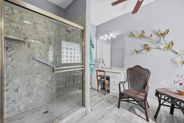 bathroom featuring ceiling fan, vaulted ceiling, an enclosed shower, vanity, and hardwood / wood-style flooring