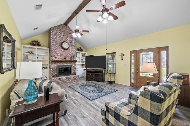 living room with hardwood / wood-style floors, lofted ceiling with beams, a brick fireplace, and ceiling fan