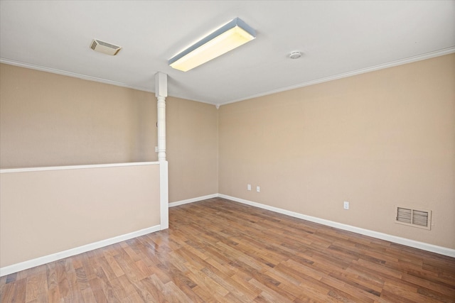 spare room with light hardwood / wood-style flooring and crown molding