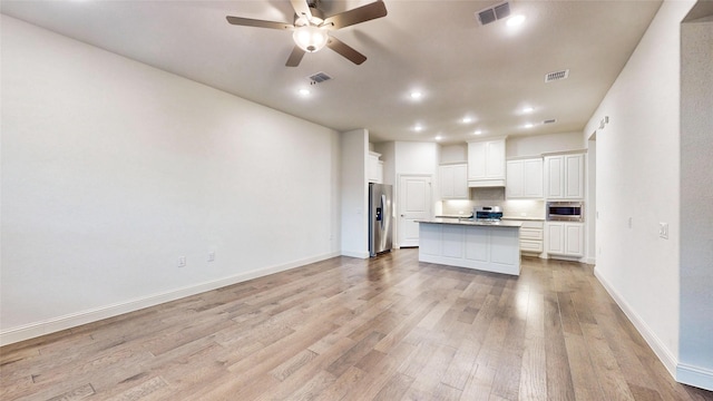 kitchen with white cabinets, appliances with stainless steel finishes, light wood-type flooring, and a kitchen island