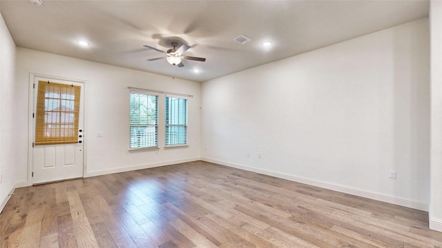 spare room with ceiling fan and light wood-type flooring