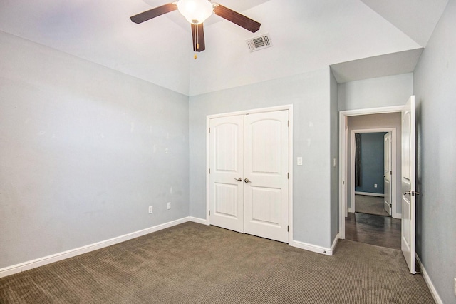 unfurnished bedroom with a closet, dark carpet, ceiling fan, and lofted ceiling