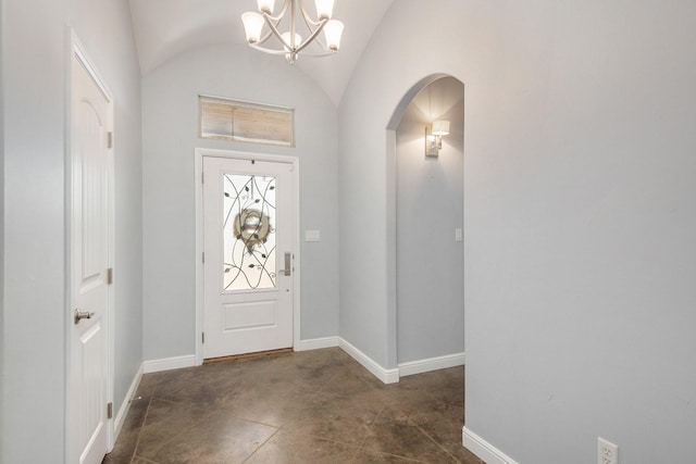 entryway featuring arched walkways, a notable chandelier, vaulted ceiling, and baseboards