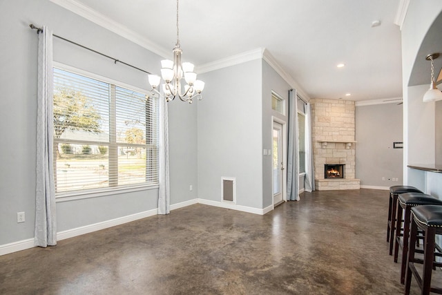 dining space with ornamental molding, a fireplace, and a chandelier