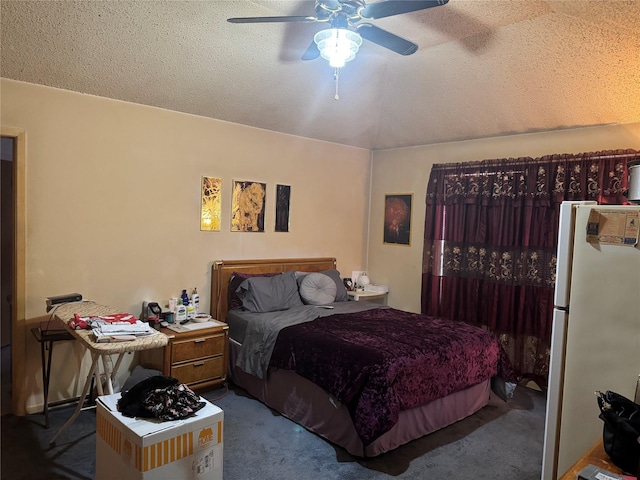 carpeted bedroom with ceiling fan, white fridge, and a textured ceiling