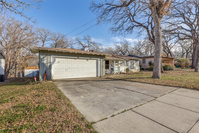 ranch-style house with central AC unit, a garage, and a front lawn