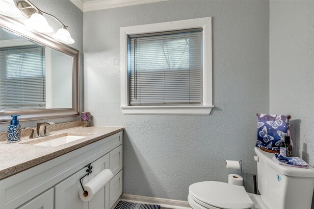 bathroom with crown molding, vanity, and toilet