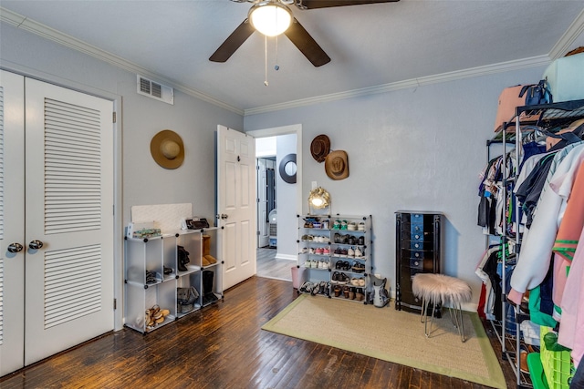 interior space with ornamental molding, ceiling fan, and dark wood-type flooring