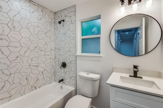 full bathroom featuring tiled shower / bath, vanity, and toilet