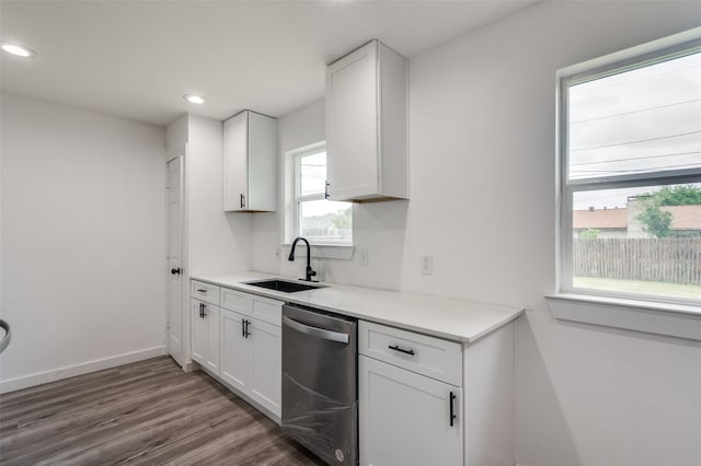 kitchen with white cabinets, dark hardwood / wood-style flooring, stainless steel dishwasher, and sink