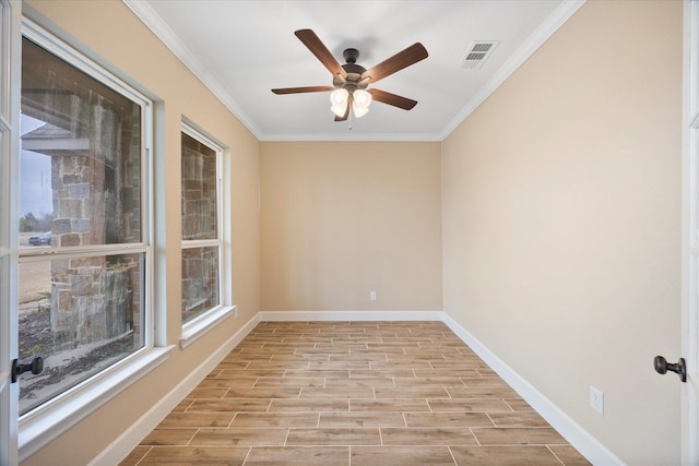 spare room featuring ornamental molding, a ceiling fan, visible vents, and light wood-style flooring