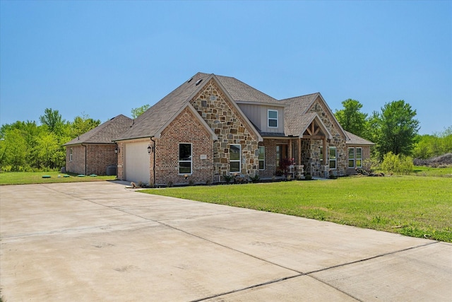 craftsman-style house featuring stone siding, an attached garage, a front yard, brick siding, and driveway