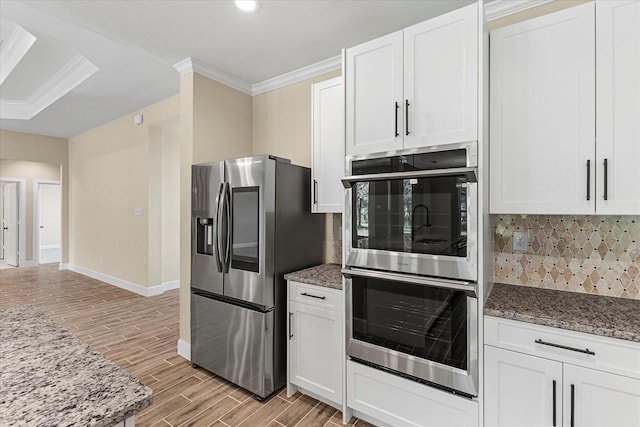 kitchen featuring stone counters, light wood-style flooring, baseboards, decorative backsplash, and stainless steel appliances