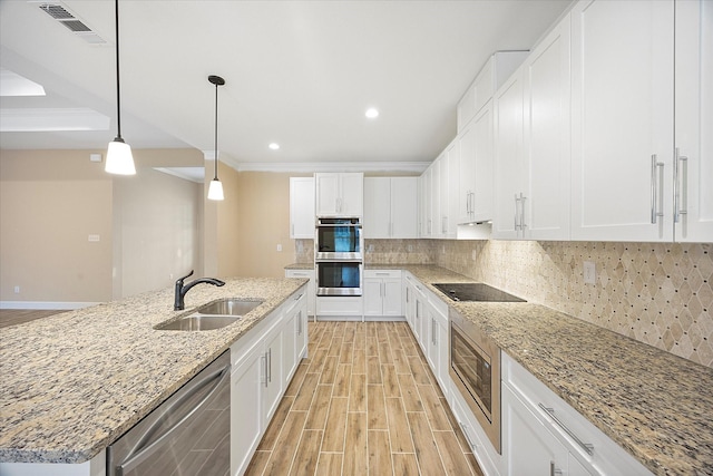 kitchen with white cabinetry, light wood-style floors, stainless steel appliances, and a sink