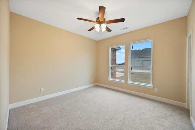 unfurnished room with carpet flooring, visible vents, baseboards, and ceiling fan