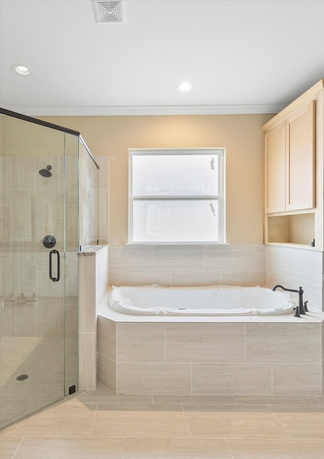 full bathroom featuring a stall shower, ornamental molding, visible vents, tile patterned floors, and a garden tub