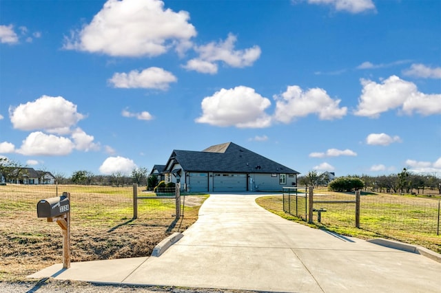 view of front facade with a front yard, a rural view, and a garage