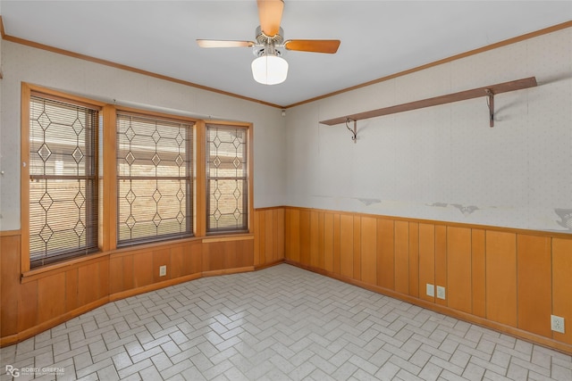 unfurnished room with ceiling fan and crown molding