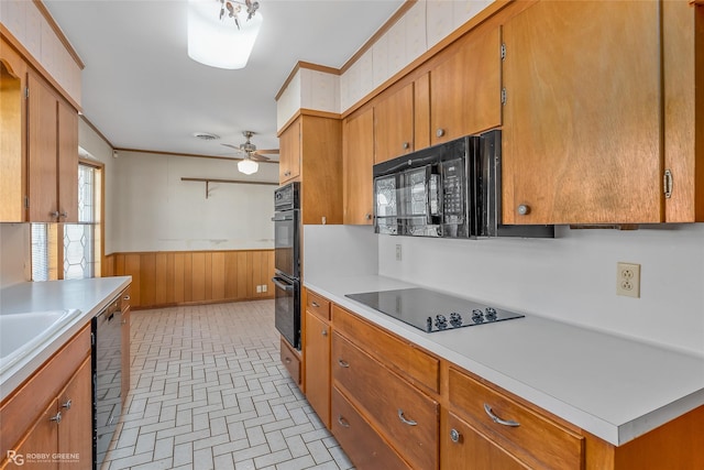 kitchen with crown molding, ceiling fan, wood walls, and black appliances