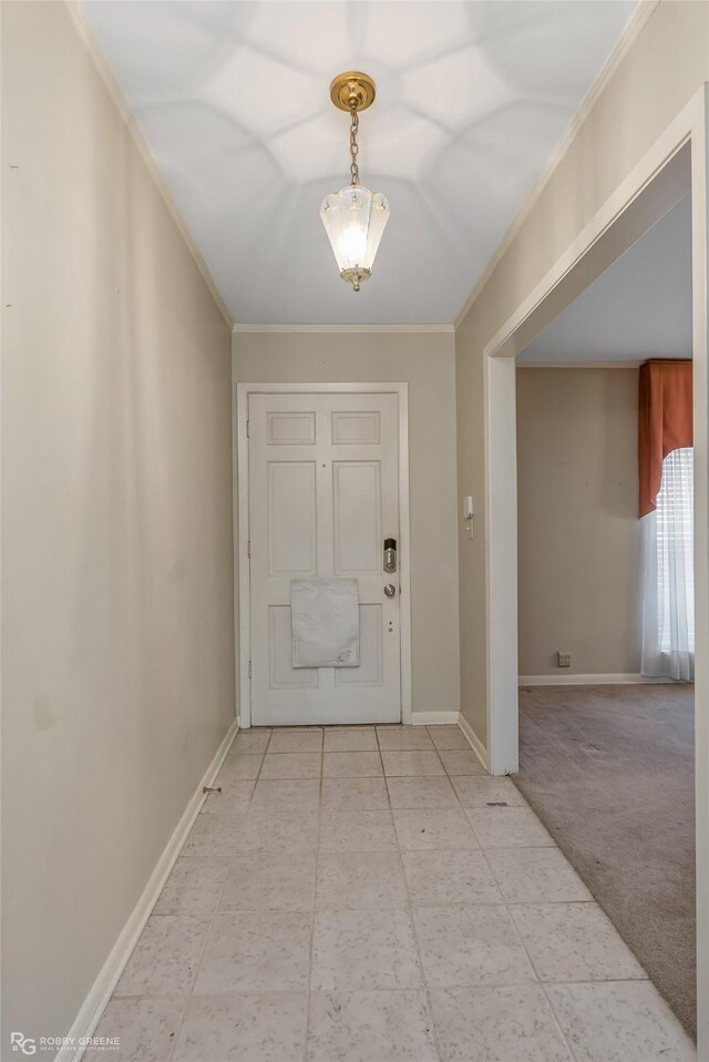 carpeted foyer entrance with ornamental molding