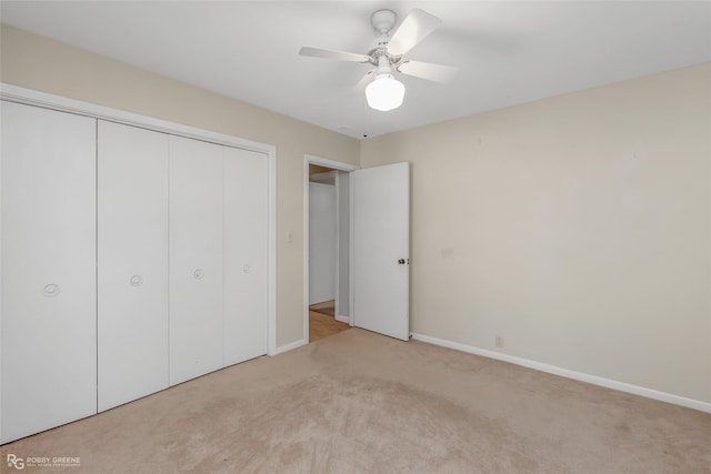 unfurnished bedroom with ceiling fan, a closet, and light carpet