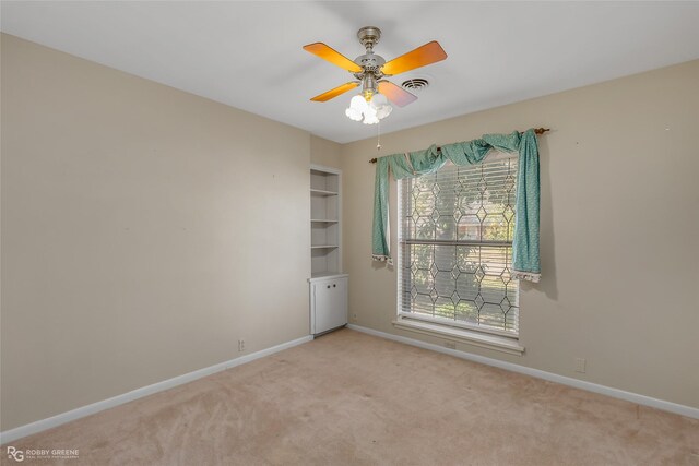 spare room featuring ceiling fan and light colored carpet